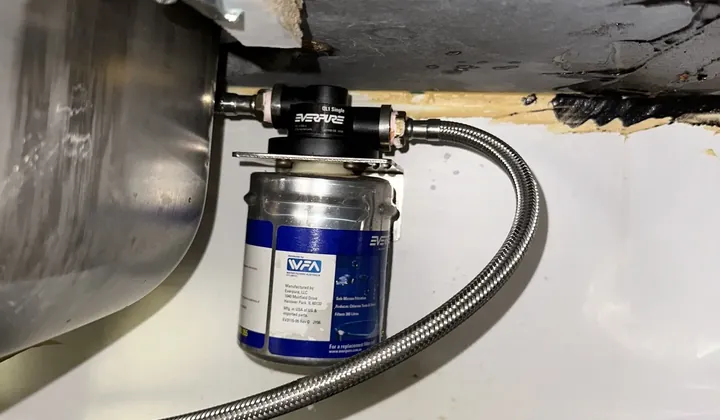 Water filter cartridge on a bracket with a braided hose under a kitchen sink in Seven Hills