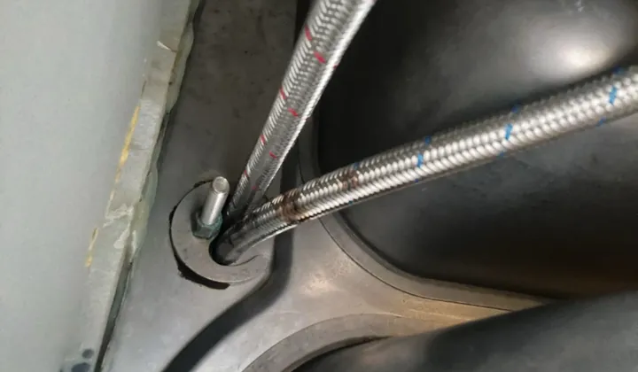 Hot and cold braided hoses running up to a kitchen tap under the sink in Waterloo
