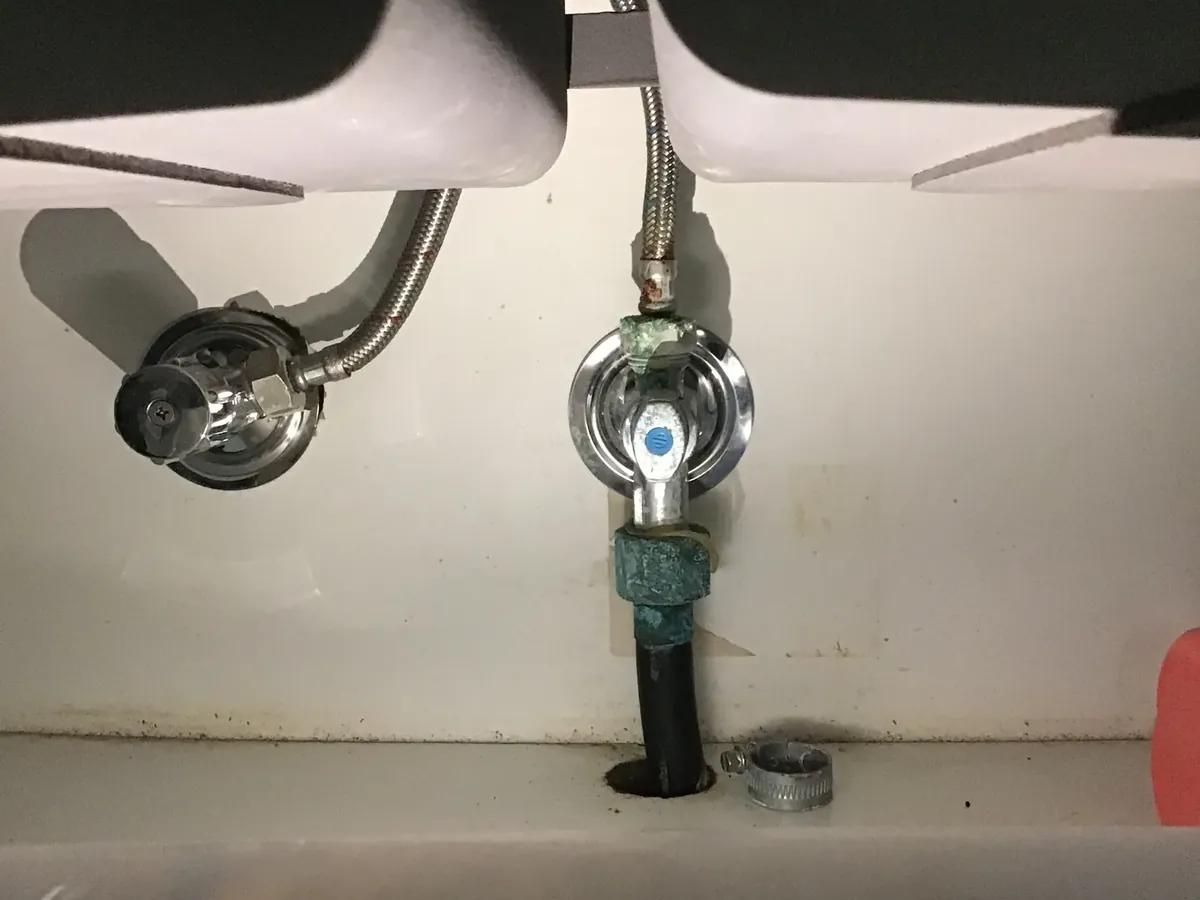 Corroded valve fitting and braided hoses under a kitchen sink in Rooty Hill