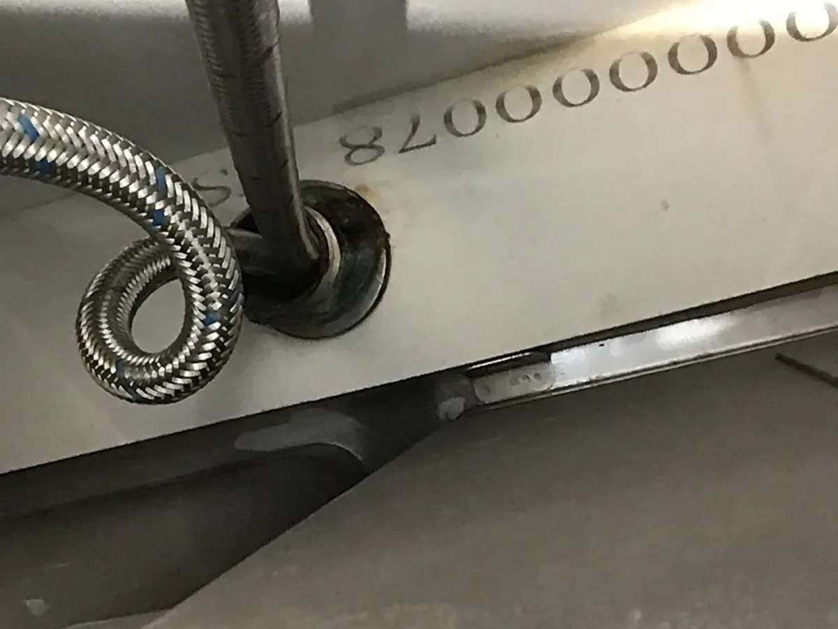 Braided hot and cold hoses running up through the underside of a kitchen sink in Rooty Hill