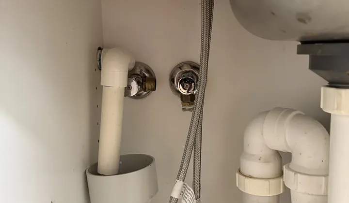 Braided mixer hose and two isolation valves under a kitchen sink in Bella Vista