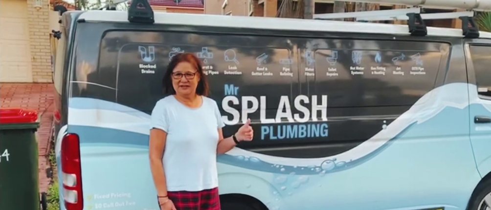 Mr Splash Plumbing customer standing beside a branded Mr Splash van