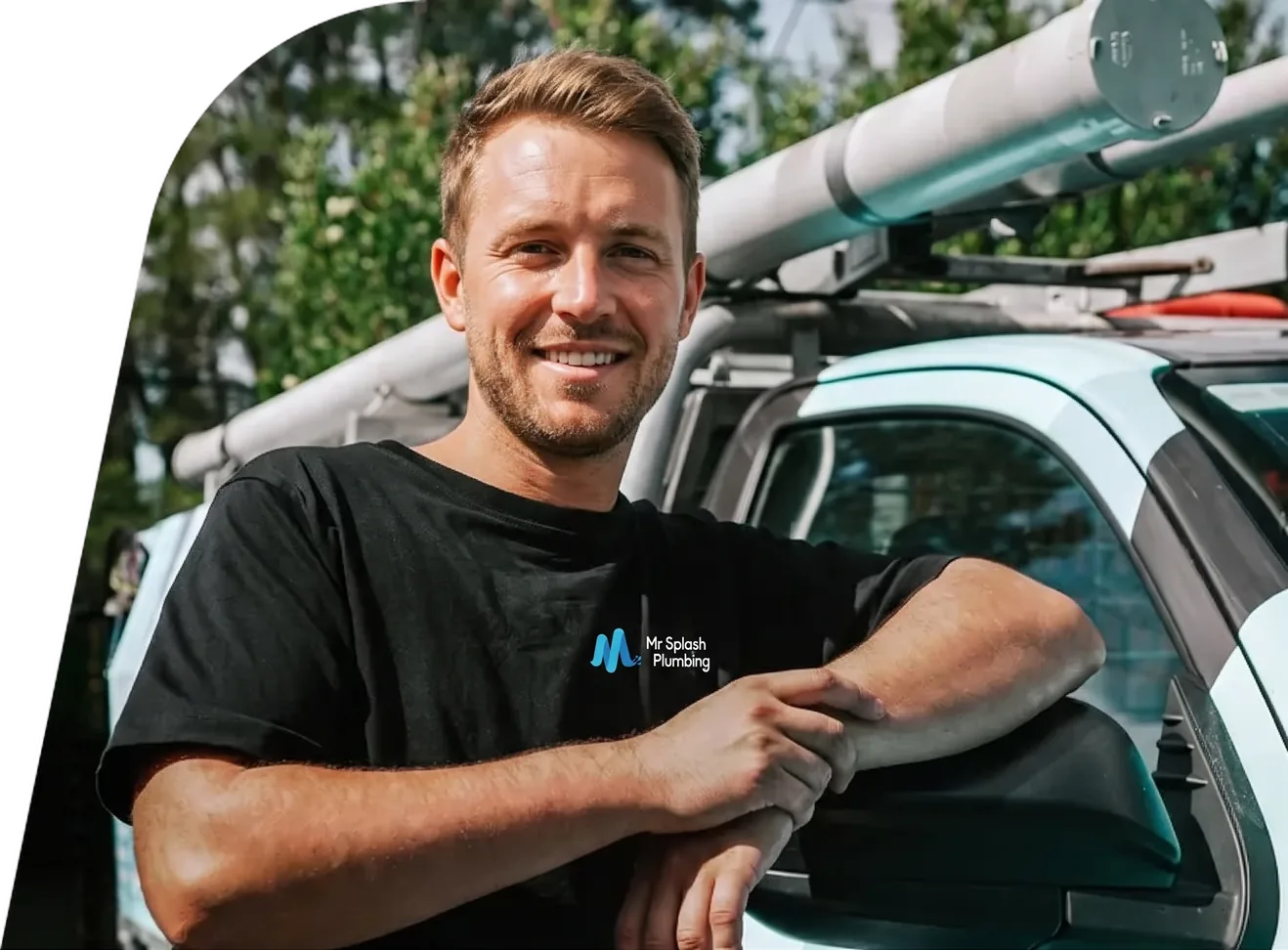 Smiling plumber leaning on the open door of a work ute