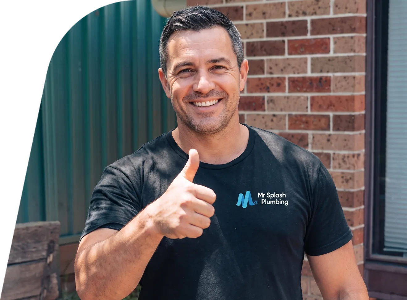 Thumbs up from a plumber outside a red brick house